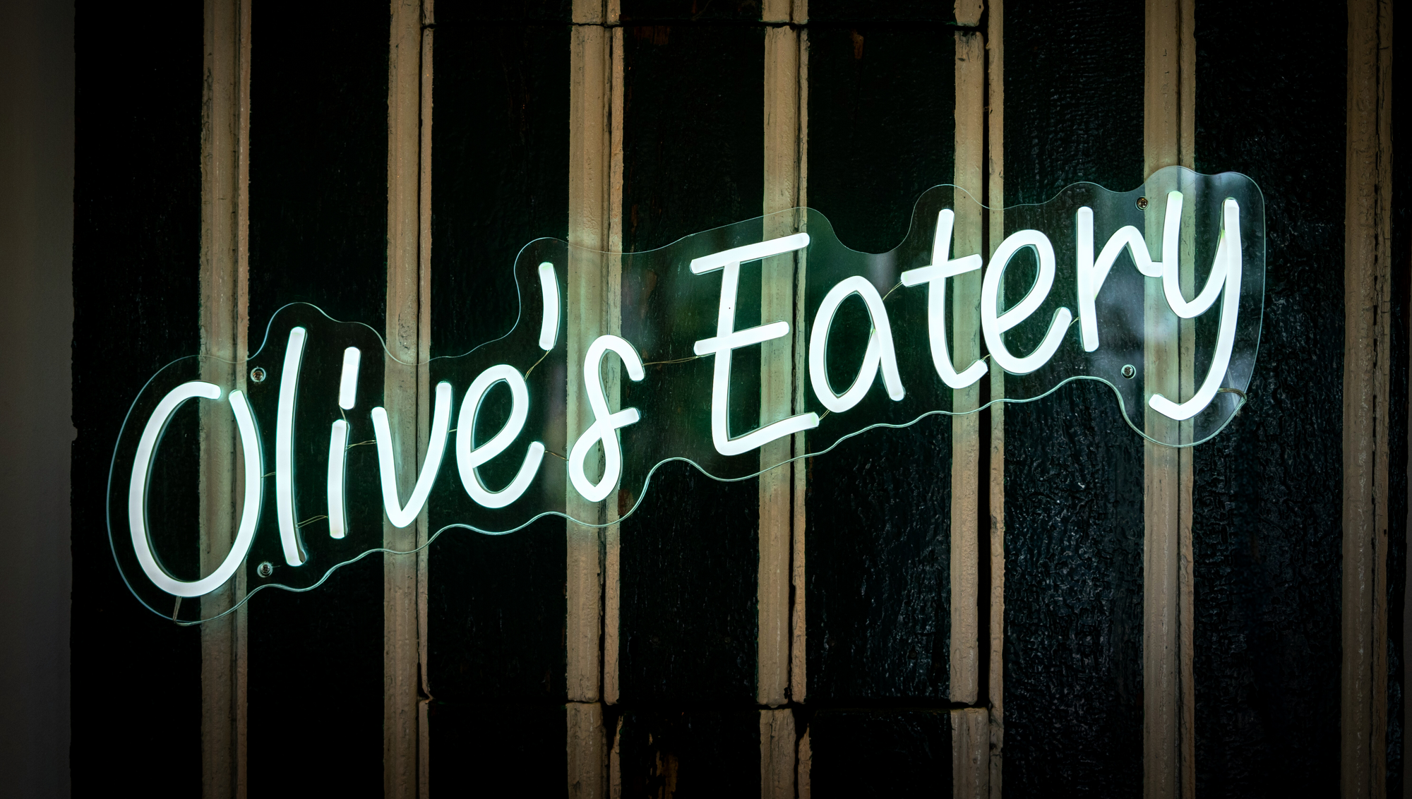 The glowing Olive's Eatery neon sign