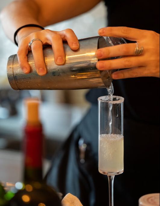 A handcrafted drink being poured at Olive & Bee